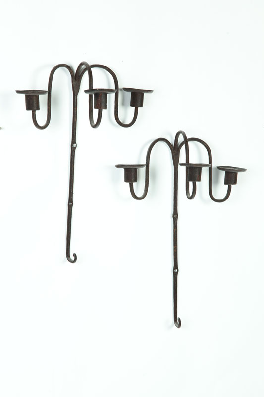 Appraisal: TWO WROUGHT IRON CANDLESCONCES American th century Three-armed sconces topped