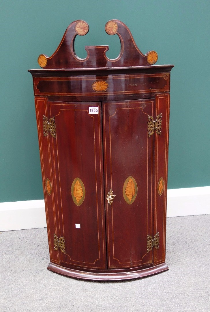 Appraisal: A George III mahogany hanging corner cupboard the broken swan