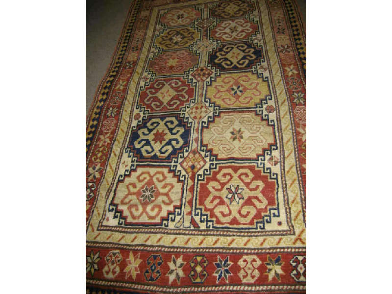 Appraisal: EARLY TH CENTURY KAZAK THROW RUG The ivory field of