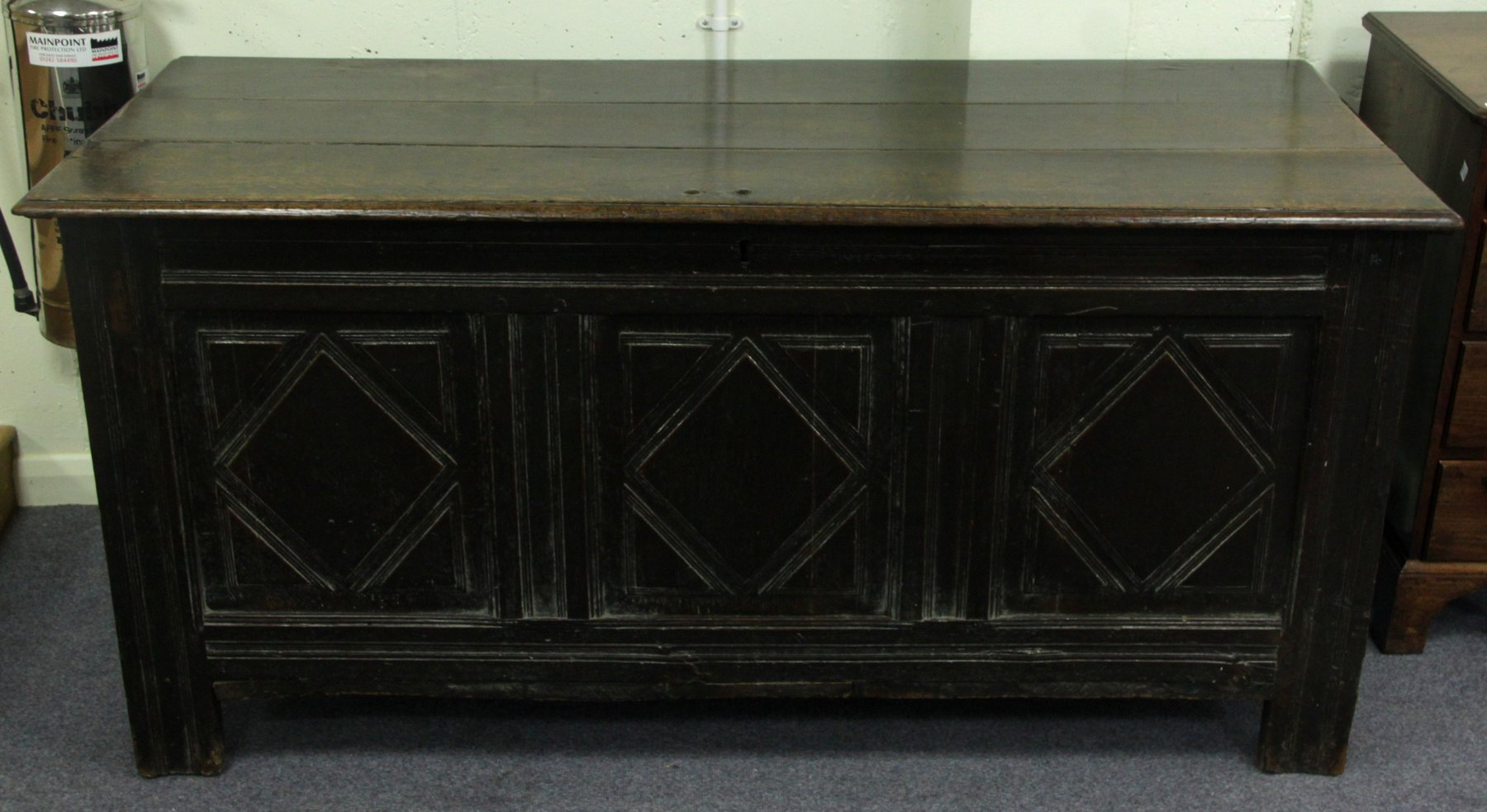 Appraisal: An oak chest with triple plank top and carved panelled