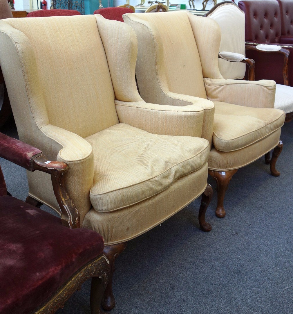 Appraisal: A pair of George I style wingback armchairs on walnut