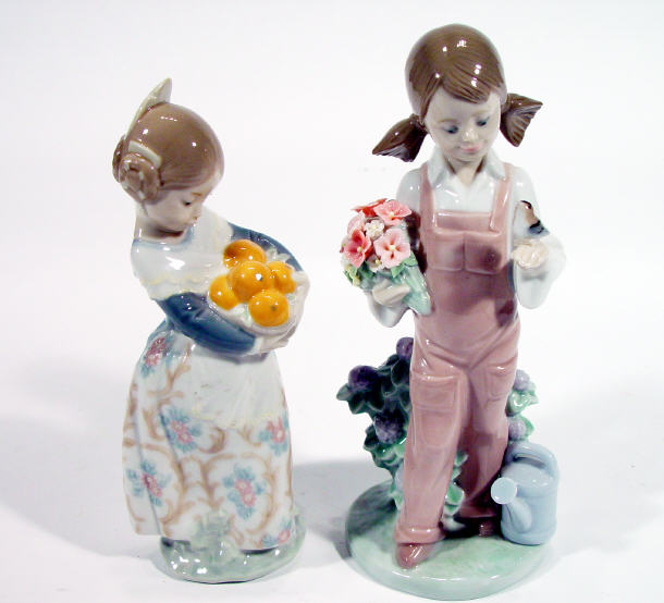 Appraisal: Two Lladro porcelain figurines one clutching a basket of oranges