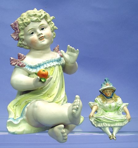 Appraisal: Pair of bisque figurines unmarked child sitting up holding a