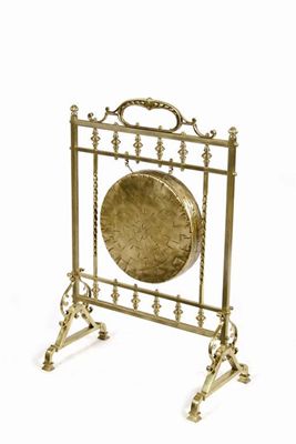 Appraisal: A hammered brass dinner gong on a brass stand in