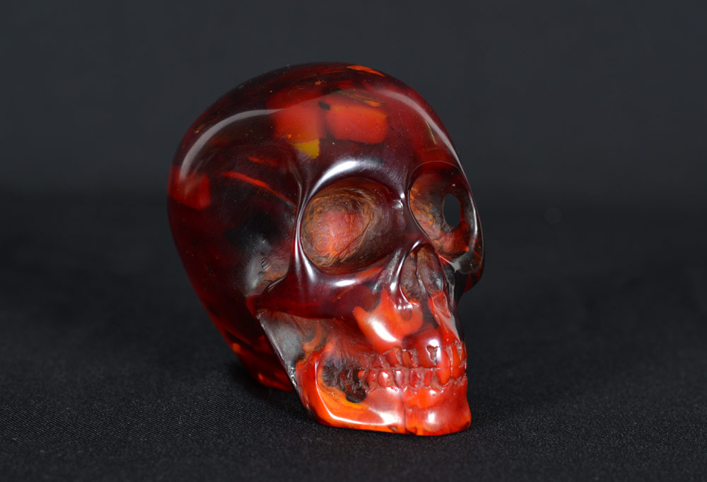 Appraisal: CARVED CHERRY AMBER SKULL FIGURE Carved cherry amber '' h