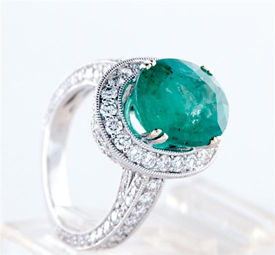 Appraisal: Emerald and diamond ring centered by oval emerald ct and