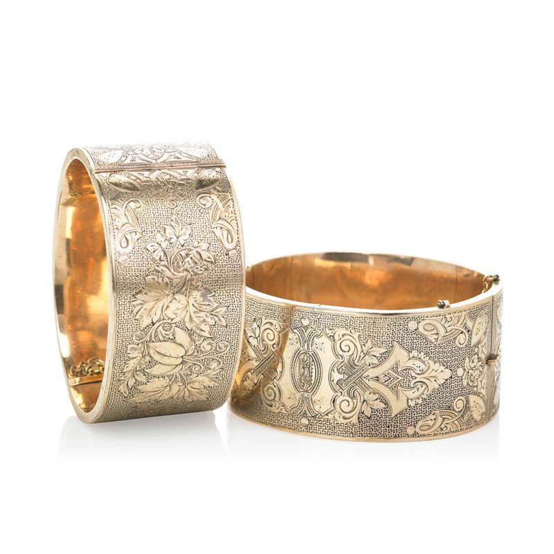 Appraisal: TWO WIDE ENGRAVED HINGED BANGLE BRACELETS Baroque chasings on stippled