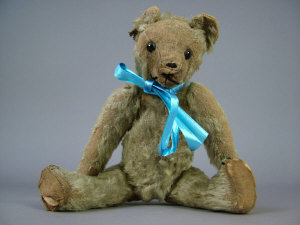 Appraisal: A mohair teddy bear with boot-button eyes and wood wool