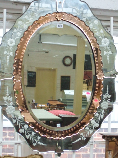 Appraisal: An oval wall mirror with an amber mirrored glass border