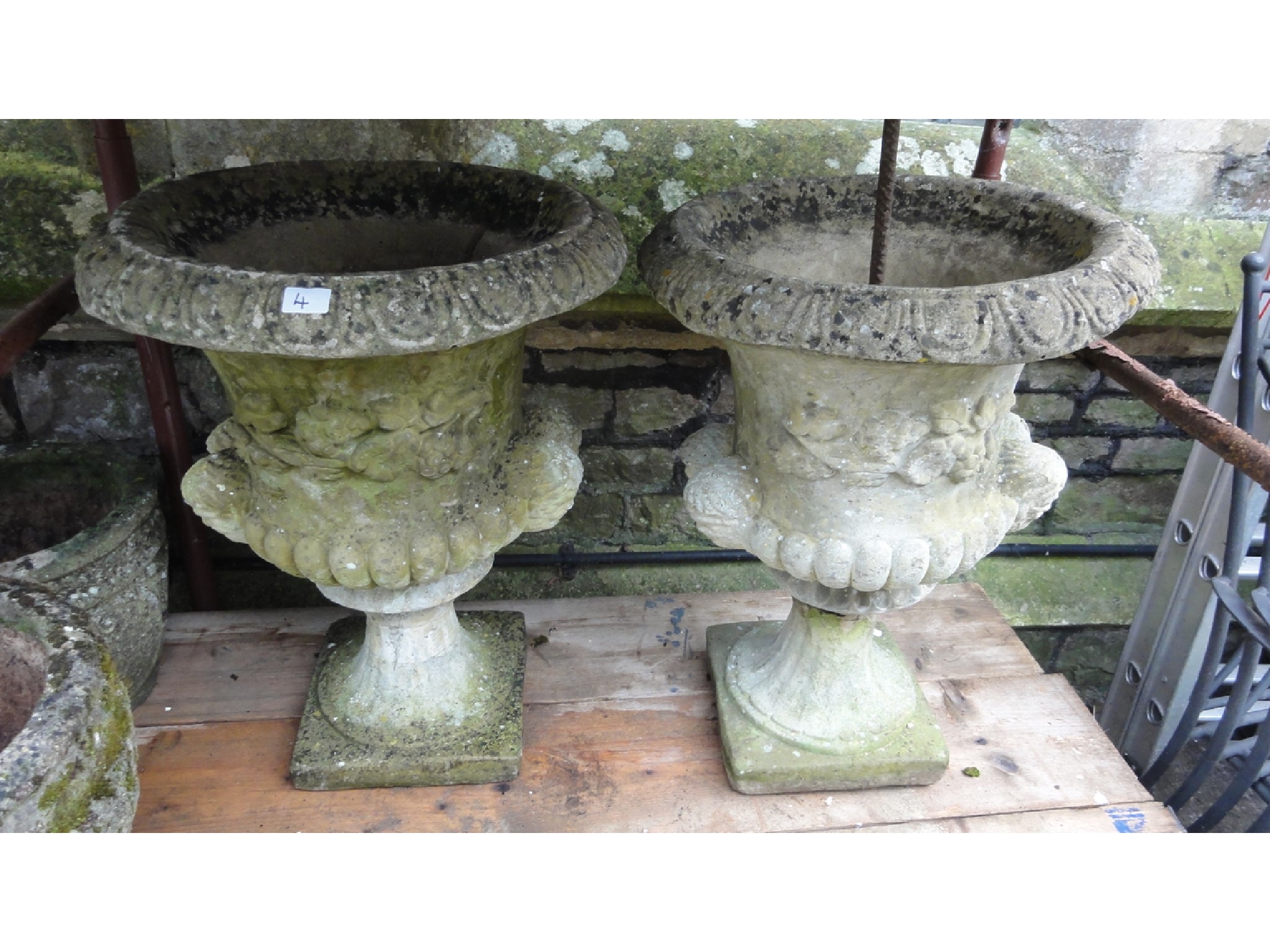 Appraisal: A pair of weathered cast composition stone campana shaped garden