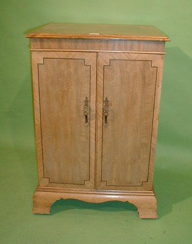 Appraisal: A reproduction mahogany two door cabinet with glass interior shelves