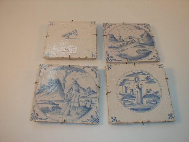 Appraisal: Four Delft tiles including two similar tiles with rural scenes