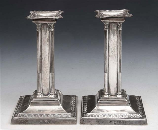 Appraisal: A PAIR OF EDWARDIAN SILVER DWARF CANDLESTICKS on square stepped