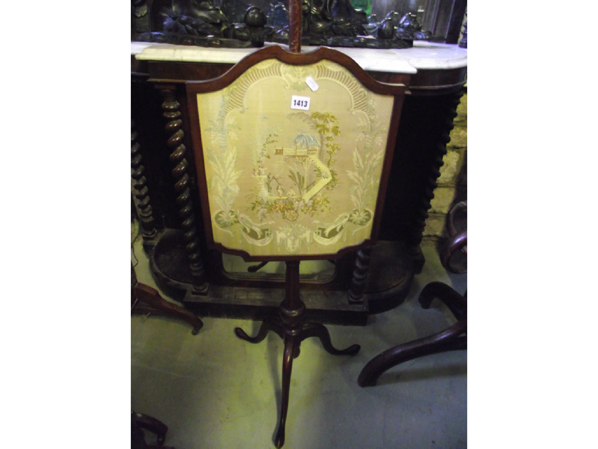 Appraisal: A th century mahogany pole screen the shaped framework enclosing