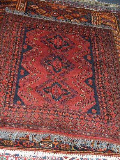 Appraisal: A TURKAMON WINE GROUND RUG decorated three geometric stars within