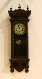 Appraisal: A modern carved timber wall clock key and pendulum in