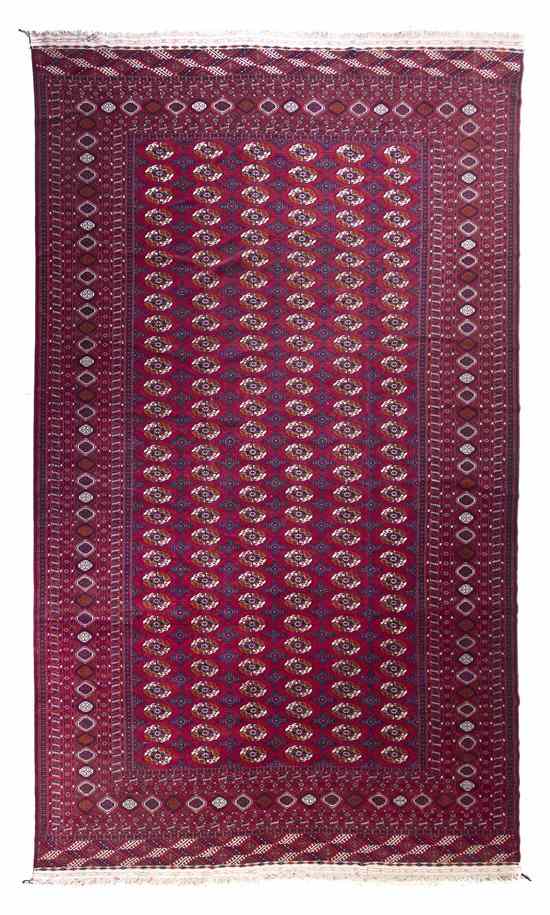 Appraisal: A Bokhara Wool Rug with repeating geometric medallions on a