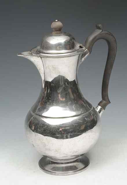 Appraisal: A SILVER WATER JUG of baluster form and scrolling ebony