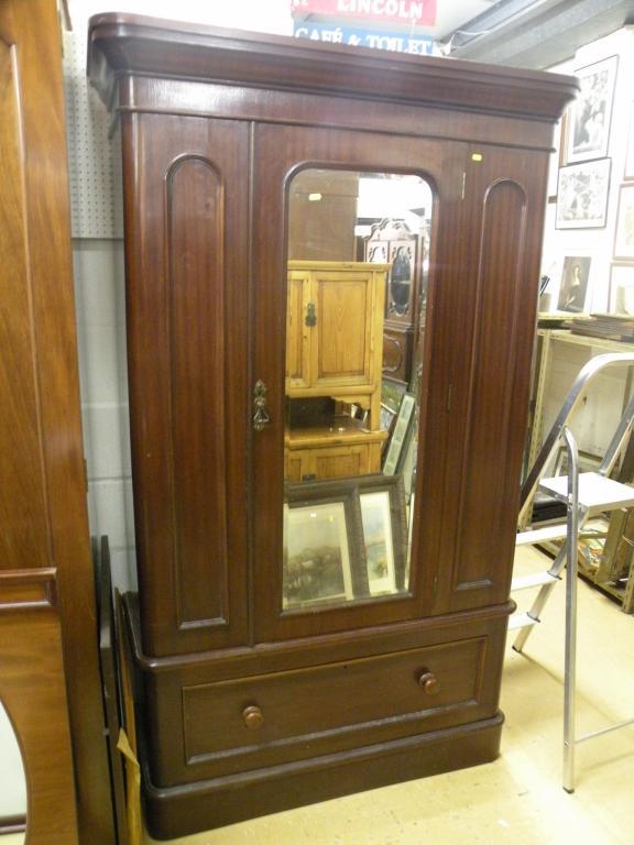 Appraisal: A Victorian mahogany wardrobe with a central mirrored door above