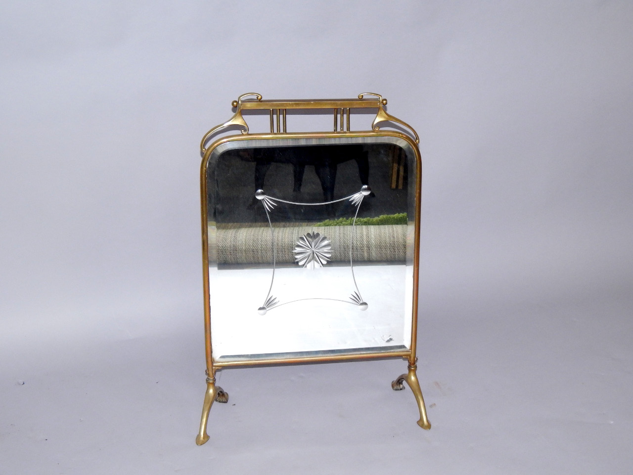 Appraisal: An Art Nouveau brass fire screen inset engraved and bevelled