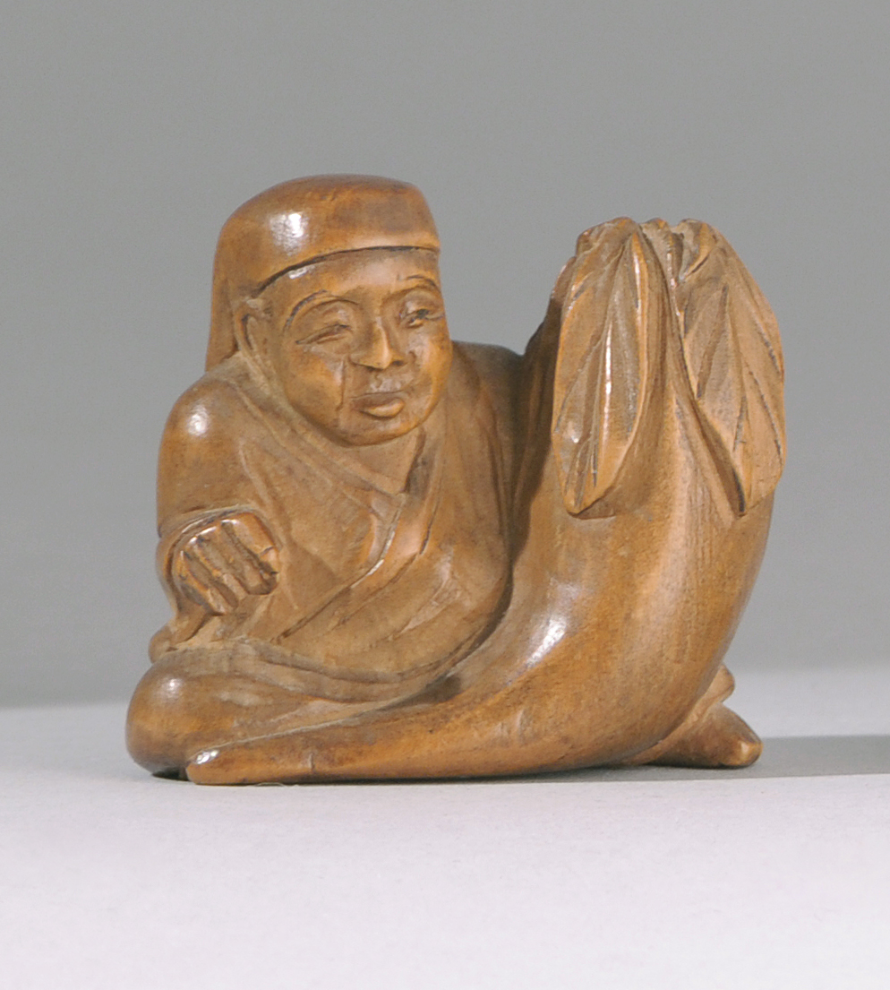 Appraisal: CARVED WOOD NETSUKE Meiji PeriodIn the form of a seated