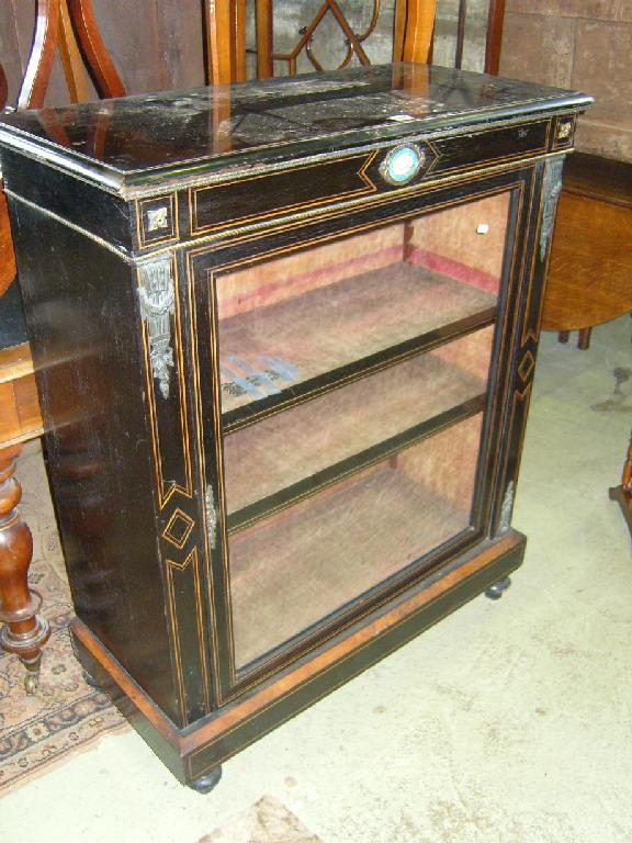 Appraisal: A Victorian ebonised display cabinet enclosed by a single glazed