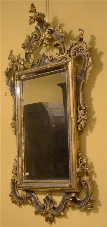 Appraisal: ROCOCO STYLE SILVERED GILT PIERCED BEVELLED MIRROR The carved and