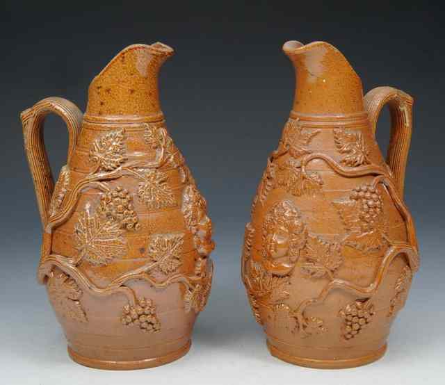 Appraisal: A PAIR OF STONEWARE JUGS with vine leaf and mask