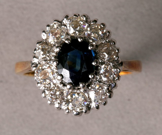 Appraisal: A SAPPHIRE AND DIAMOND CLUSTER RING oval claw set sapphire