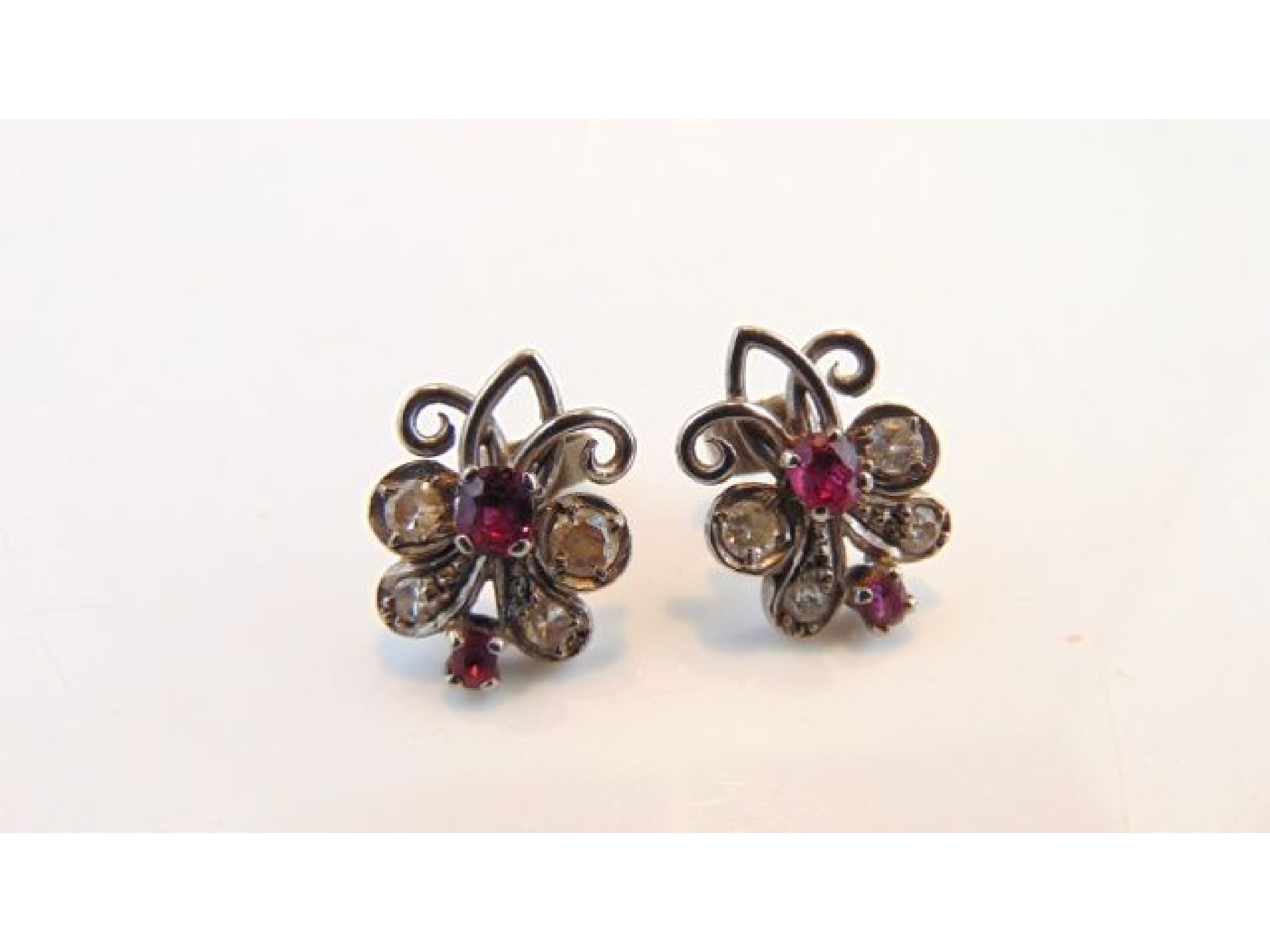 Appraisal: A pair of diamond and ruby earrings each of scrolling