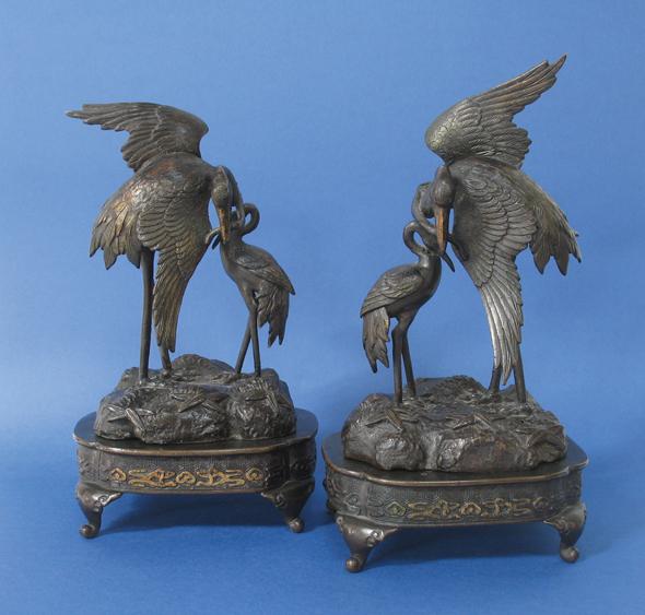 Appraisal: A PAIR OF CHINESE BRONZE GROUPS of cranes perched on