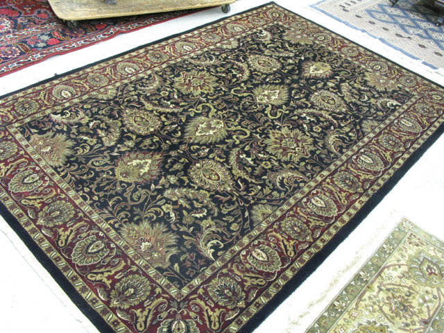 Appraisal: HAND KNOTTED ORIENTAL CARPET Indo-Persian having a floral decorated black