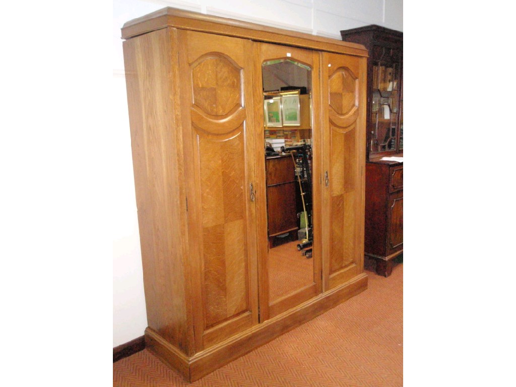 Appraisal: A 's oak triple wardrobe with moulded caddy top central