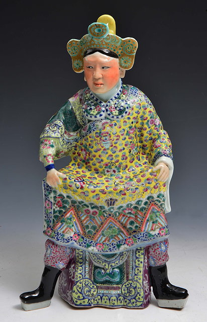 Appraisal: A CHINESE PORCELAIN FIGURE OF AN EMPEROR seated on a