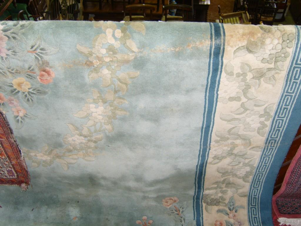 Appraisal: A large Chinese washed wool carpet with pale blue field