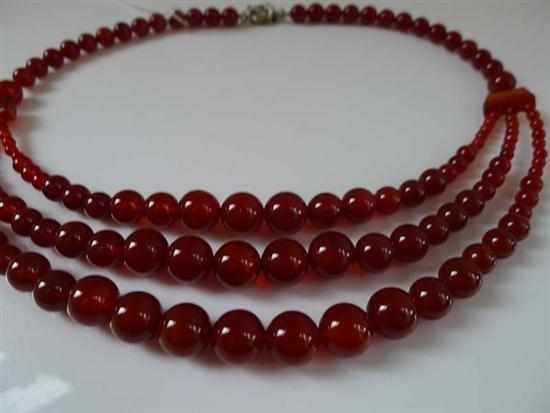 Appraisal: A TRIPLE STRAND OF GRADUATED CARNELIAN BEADS