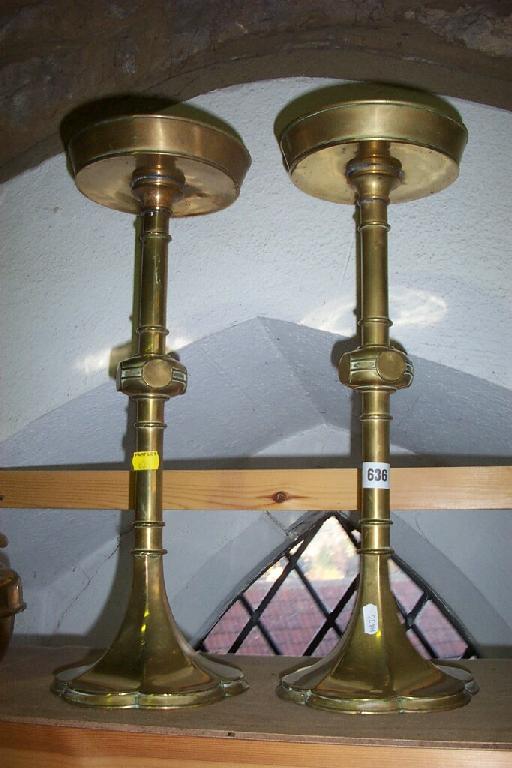 Appraisal: A pair of tall brass candlesticks with knopped decoration to