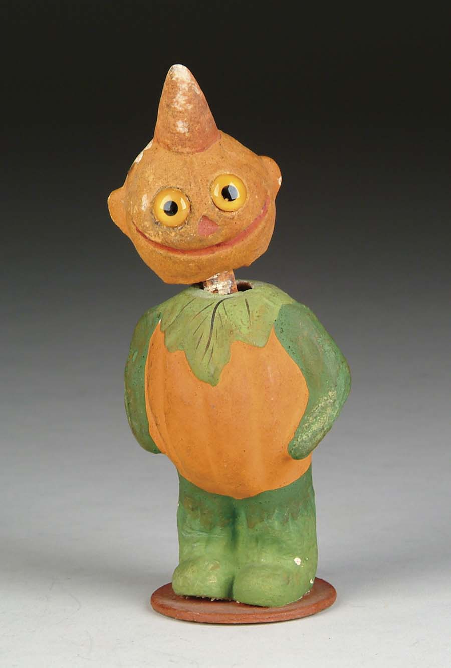 Appraisal: GLASS-EYED PUMPKIN NODDER Pumpkin-bodied figure has green arms and legs