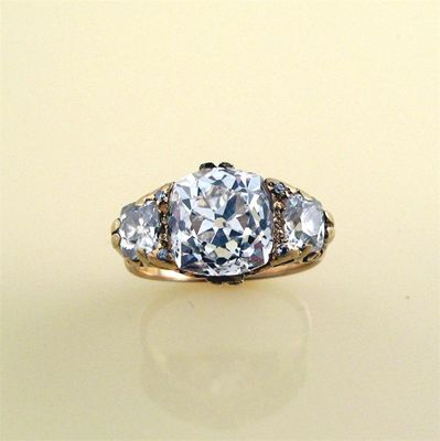 Appraisal: A diamond three stone ring The centre cushion shaped diamond