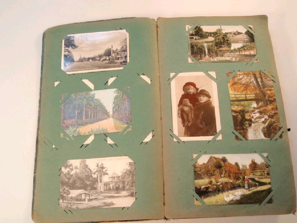 Appraisal: An early thC postcard album with approximately assorted cards