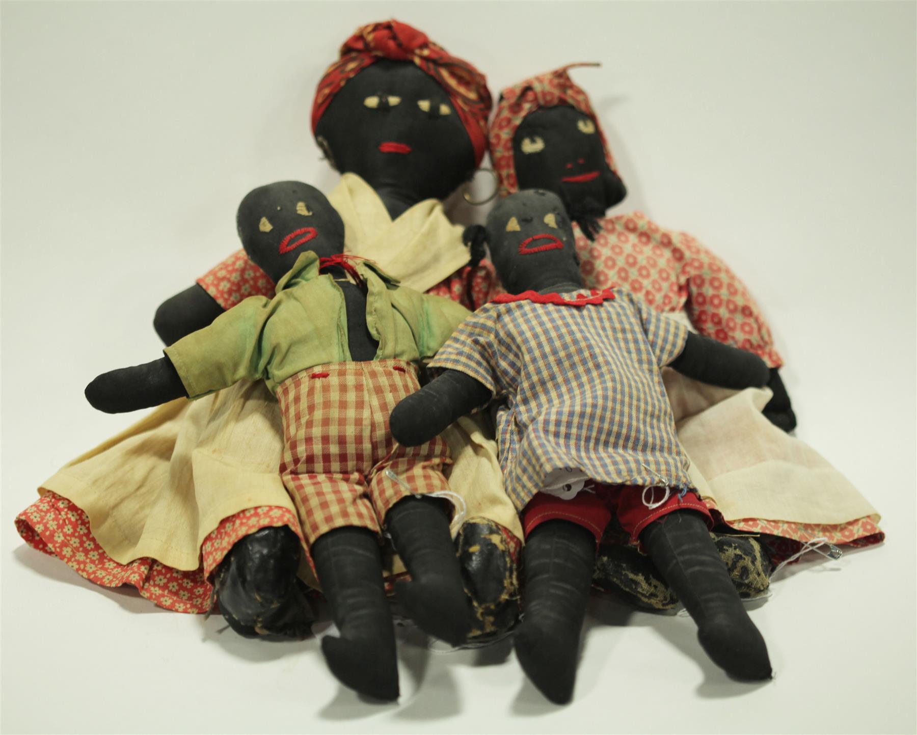 Appraisal: FOUR BLACK CLOTH DOLLS WITH STITCHED FACES Early th century