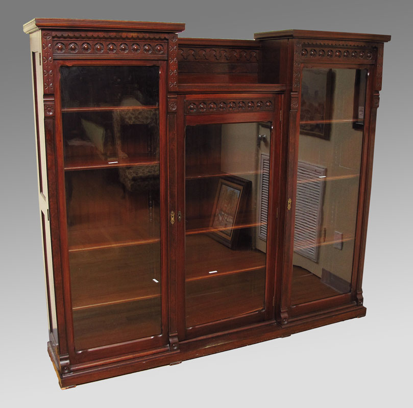 Appraisal: VICTORIAN ERA TRIPLE FRONT MAHOGANY BOOKCASE Center section surmounted by