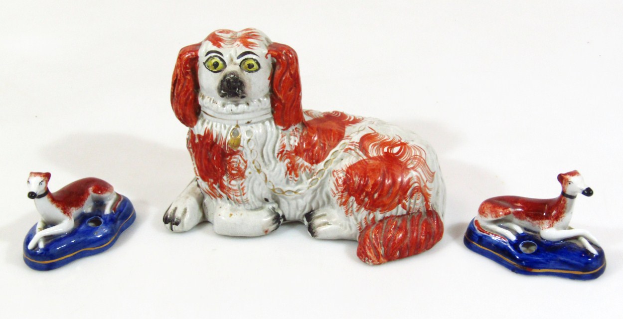 Appraisal: A thC Staffordshire pottery dog of recumbent form in orange