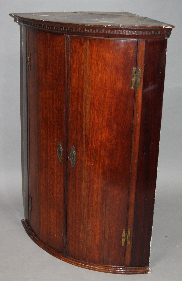 Appraisal: An thC oak hanging corner cupboard of barrel shaped outline