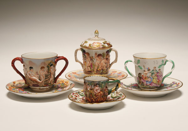 Appraisal: Four Capo di Monte figural cups and saucers puttis and