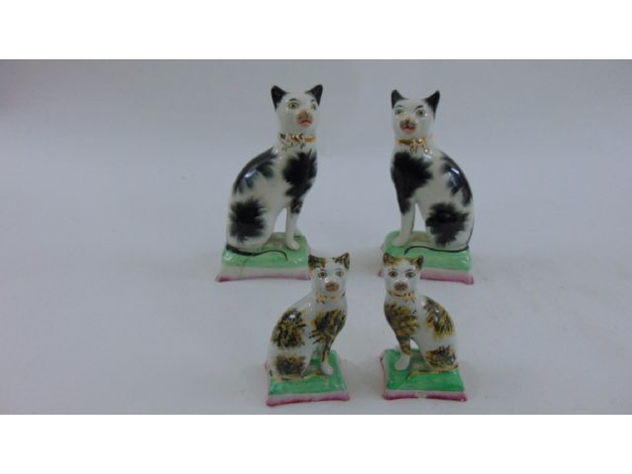 Appraisal: A pair of th century Staffordshire cats seated on green