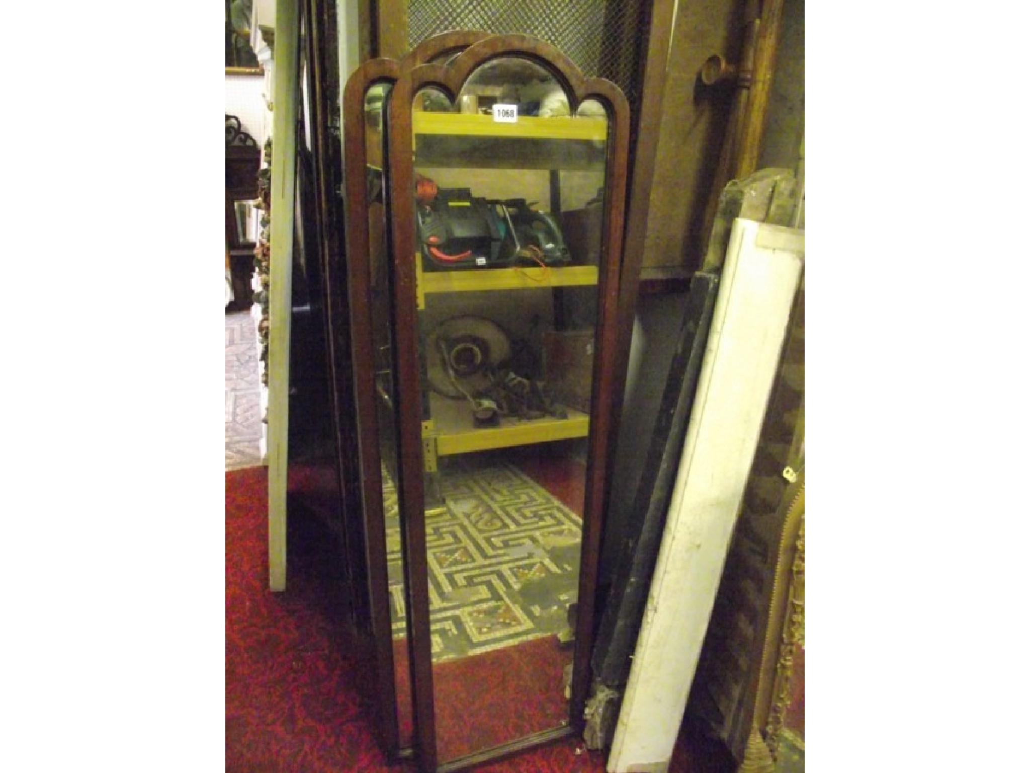 Appraisal: A pair of slender wall mirrors with moulded arched frames