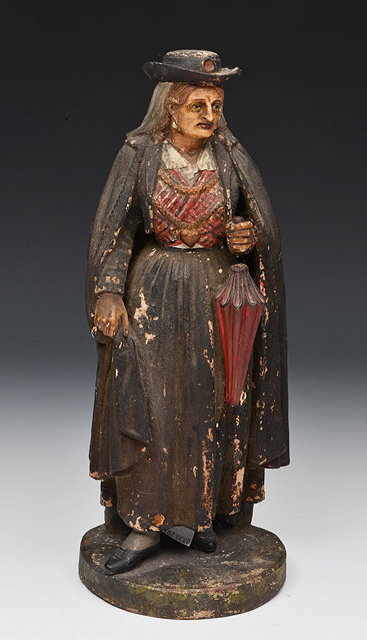 Appraisal: A PORTUGUESE POTTERY FEMALE FIGURE in traditional dress impressed Martinho