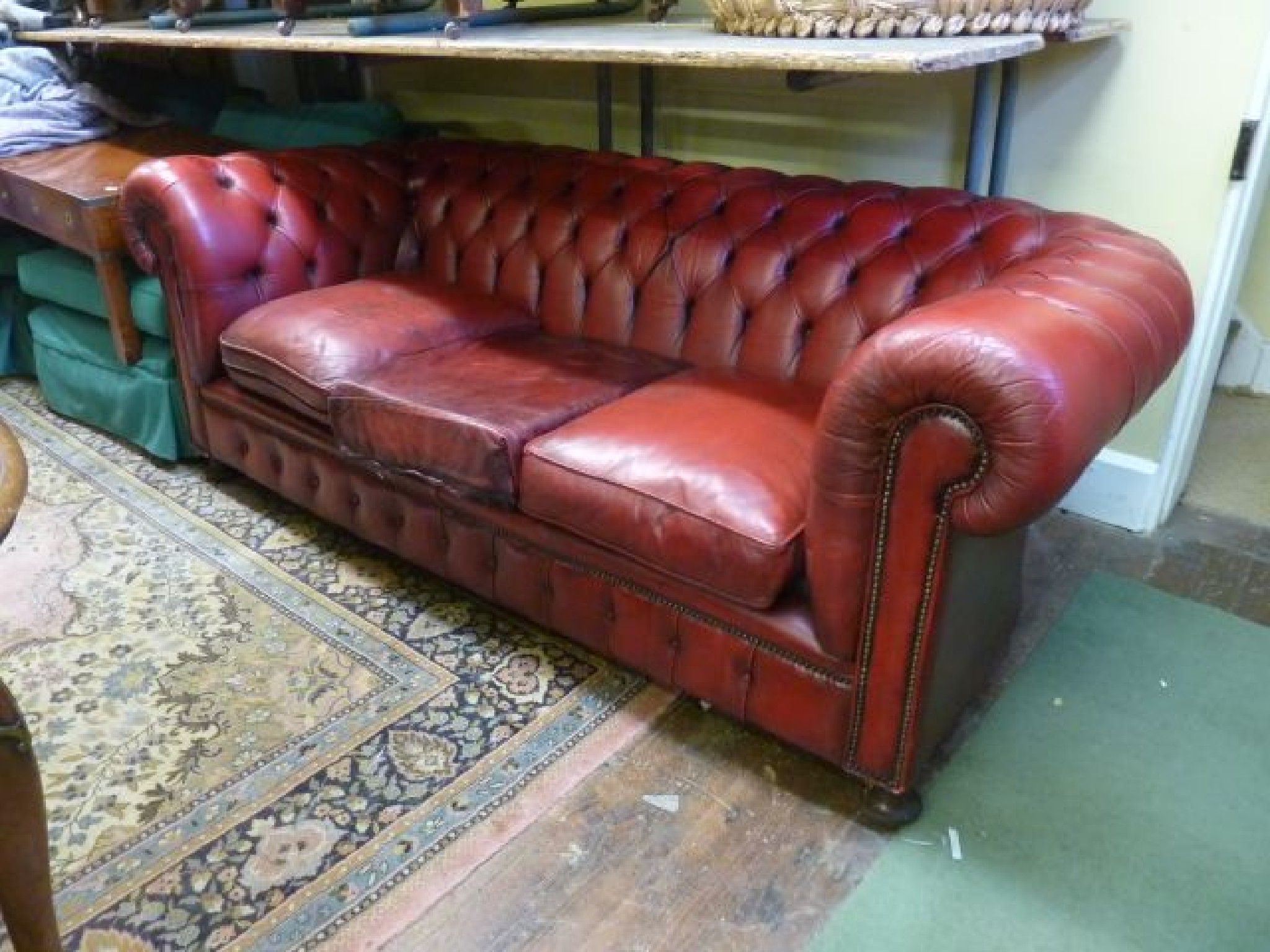 Appraisal: A traditional button back Chesterfield sofa in a red leather