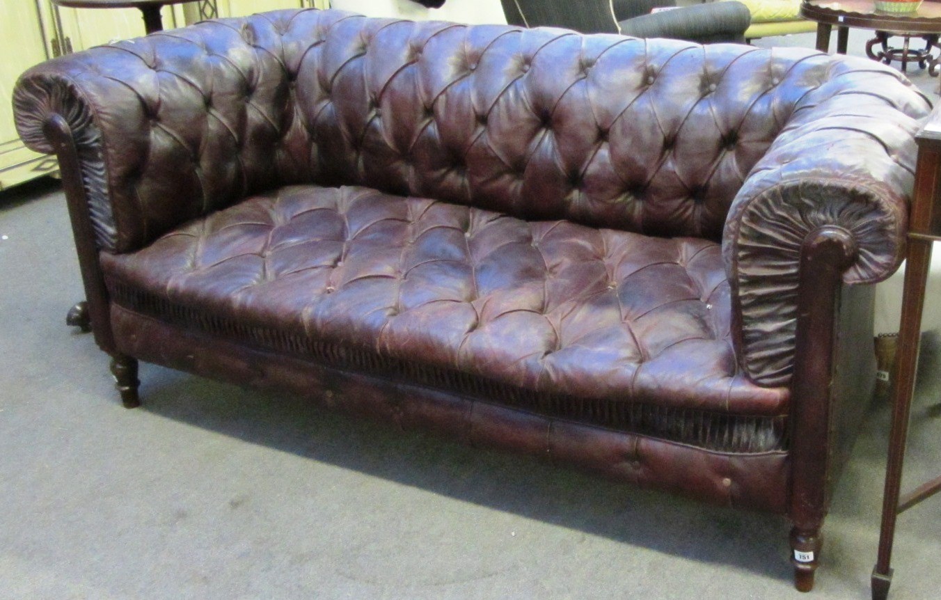 Appraisal: A rouge leather upholstered button back Chesterfield on turned supports